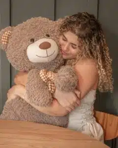 Aimer une peluche à l’âge adulte Femme tenant une peluche, symbole de réconfort et de tendresse à l’âge adulte