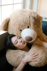 Dormir avec une peluche à 40 ans : une femme avec une grosse peluche